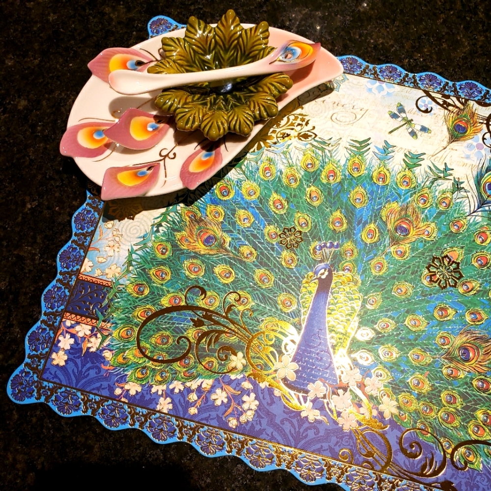 Peacock preseve dish and spoon accompanied by two peacock placemats.
